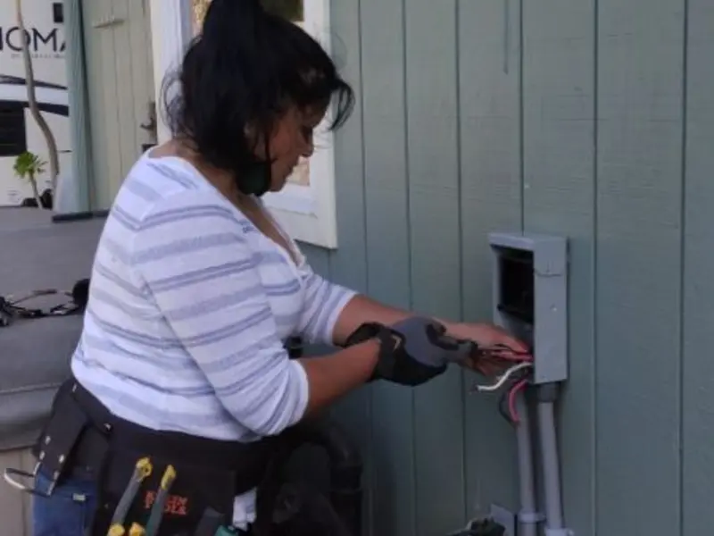 Licensed electrician wiring an exterior subpanel in Caro